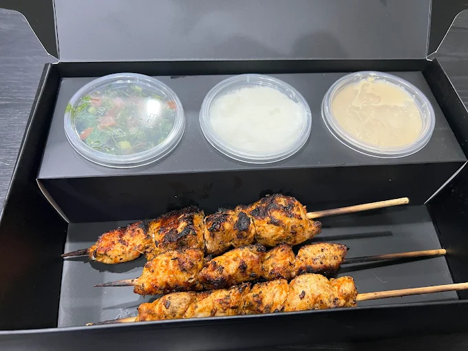 Chicken skewers in branded box with dips